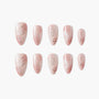 Handmade press-on nails in blush pink with butterfly, floral, and glitter designs, arranged on white background.