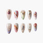 Handmade press-on nails with abstract marble patterns, gold accents, and celestial designs.