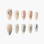 Handmade press-on nails with celestial, butterfly, and gemstone designs in pastel colors