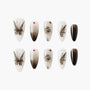 Handmade press-on nails with black butterfly, rose, and gradient designs on a white background