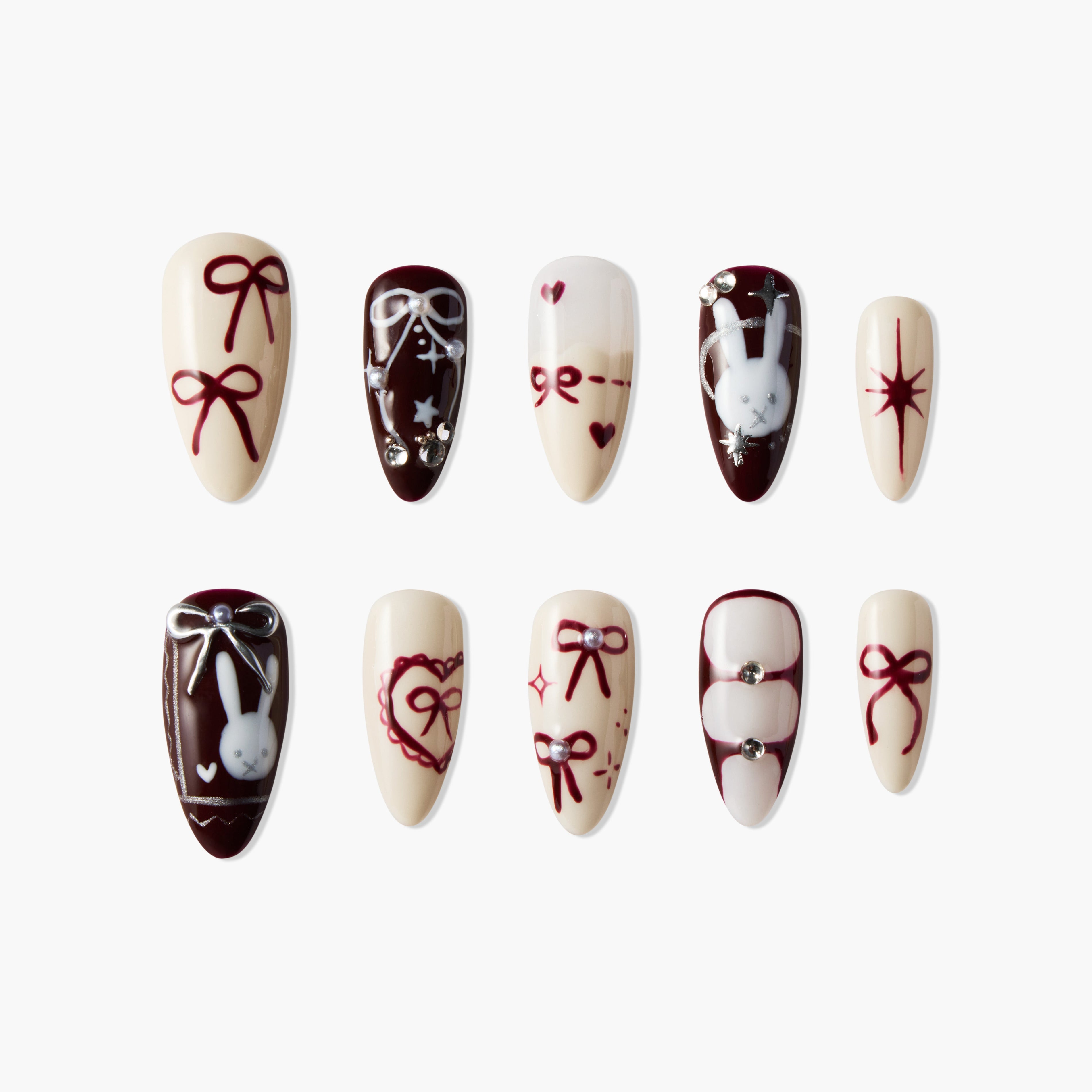 Handmade press-on nails with maroon bows, bunny art, hearts, and jewel accents on cream base