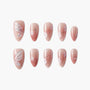 Pink press-on nails with butterfly, glitter, rhinestones, and floral nail art design