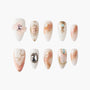 Handmade press-on nails with celestial and gold designs, pearls, and gemstone accents.