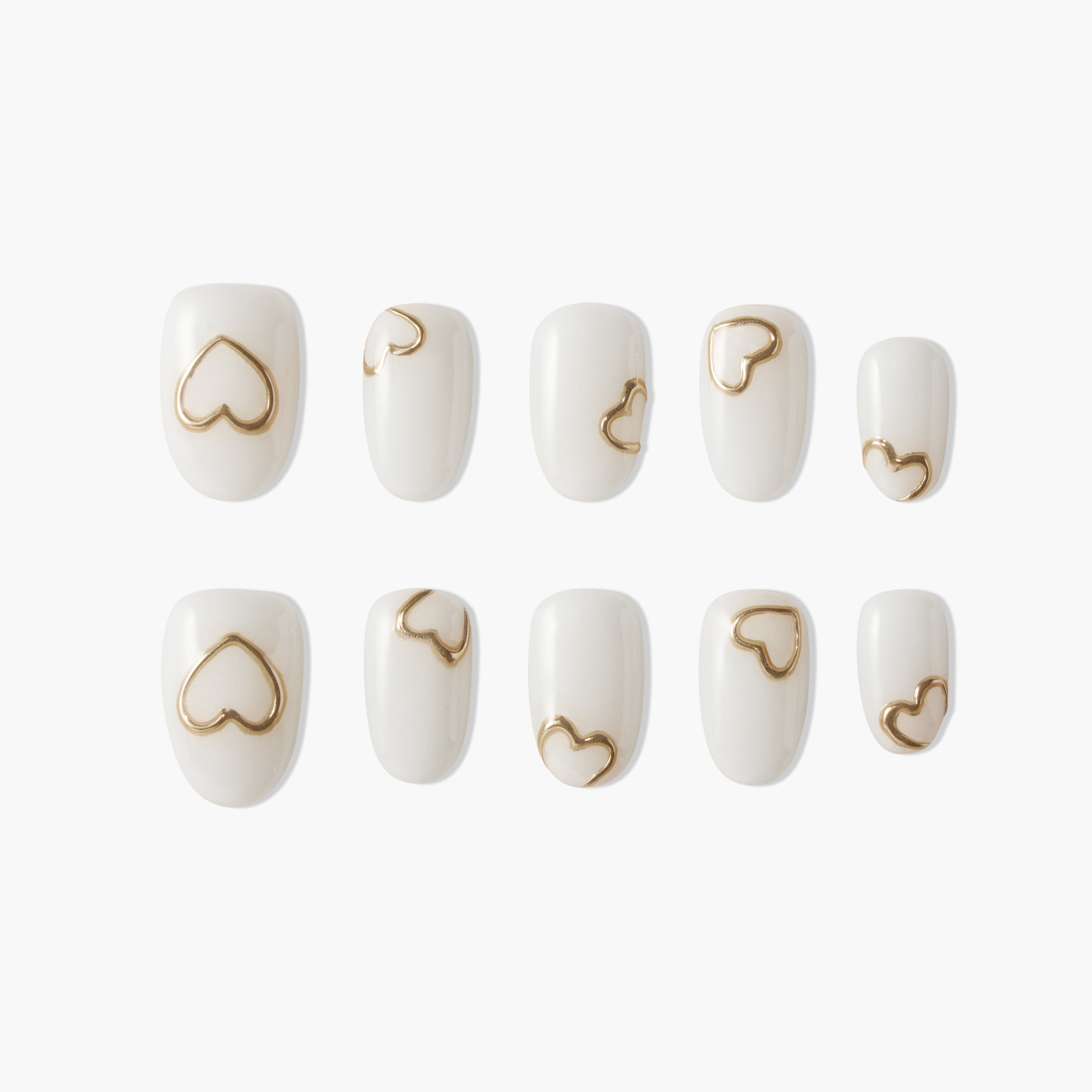 Set of white press-on nails with metallic gold heart designs on each nail, displayed on white background