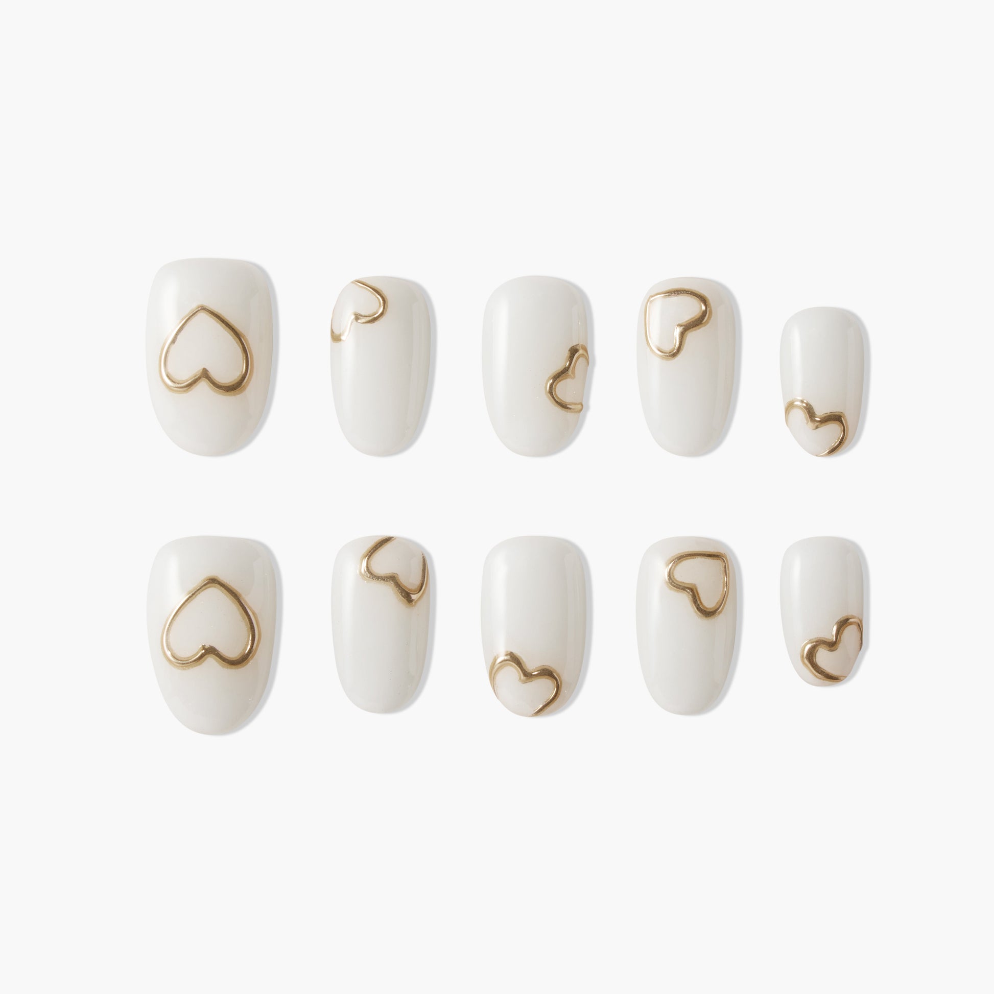 Set of white press-on nails with metallic gold heart designs on each nail, displayed on white background
