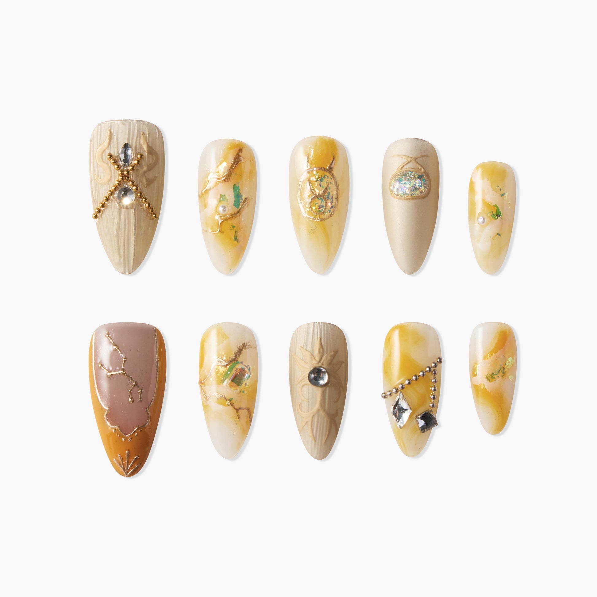 Handmade press-on nails with yellow, gold, and beige marble designs and gemstone accents