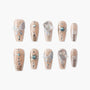 Handmade nude press-on nails with 3D butterfly, gems, metallic accents, and glitter details