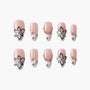 Handmade press-on nails with pink and white floral design and rhinestone accents