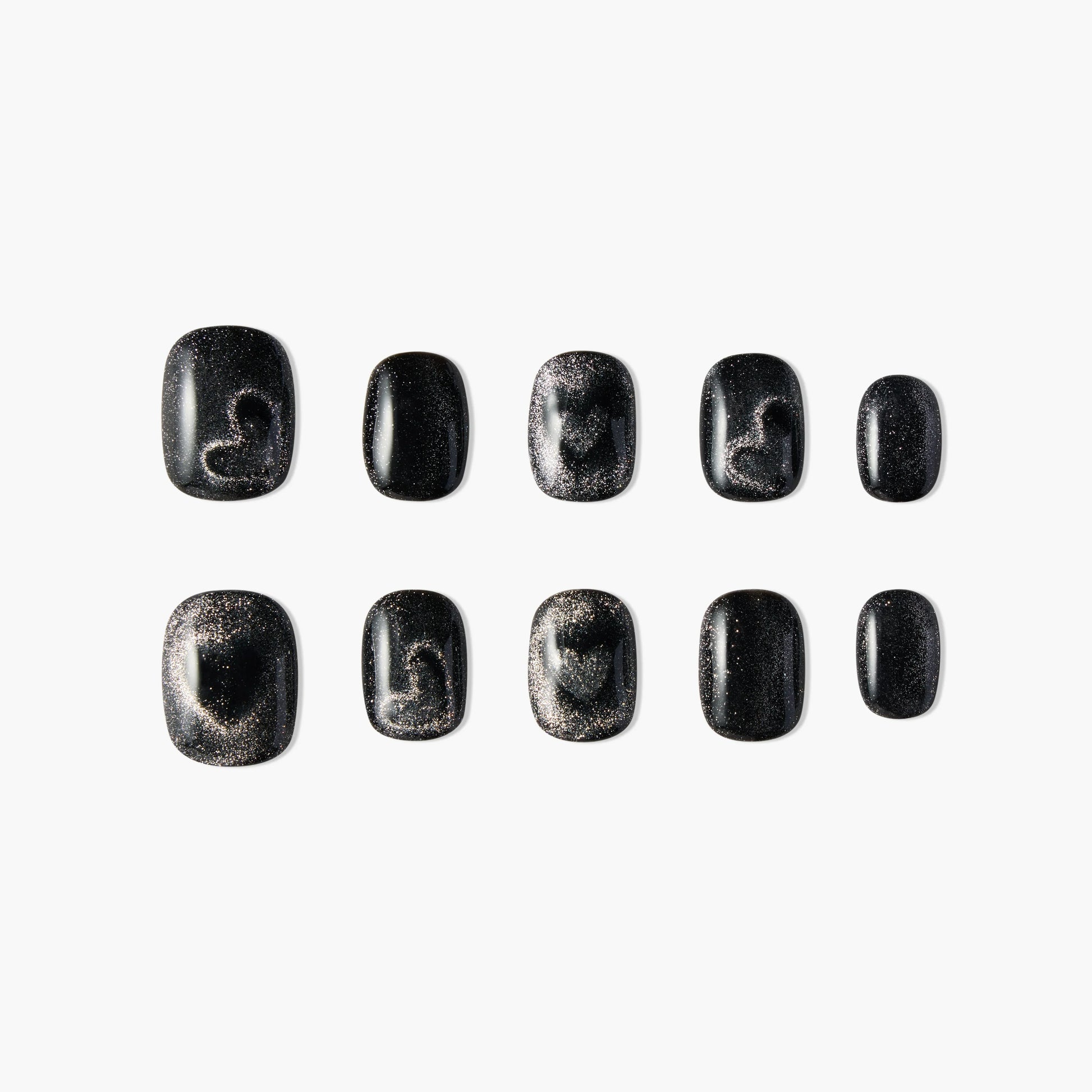 Set of black press-on nails with silver glitter and abstract heart accents, displayed on white background.