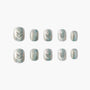 Set of shimmery silver and blue handmade press-on nails with glitter accents on white background