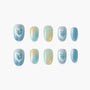 Set of ten glitter ombre press-on nails in blue, yellow, and teal on white background