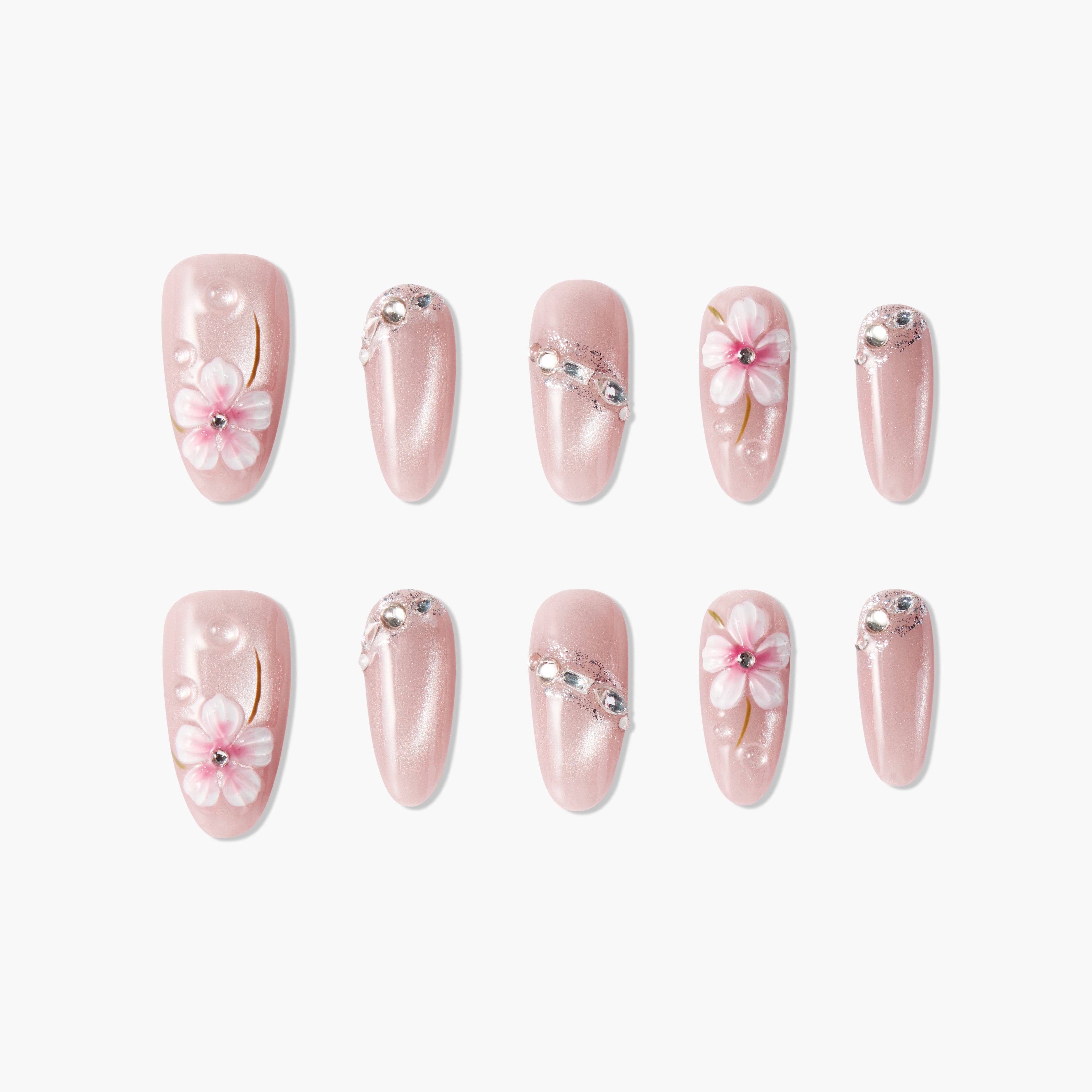 Pink press-on nails with pearl shimmer, floral designs, rhinestones, and 3D embellishments