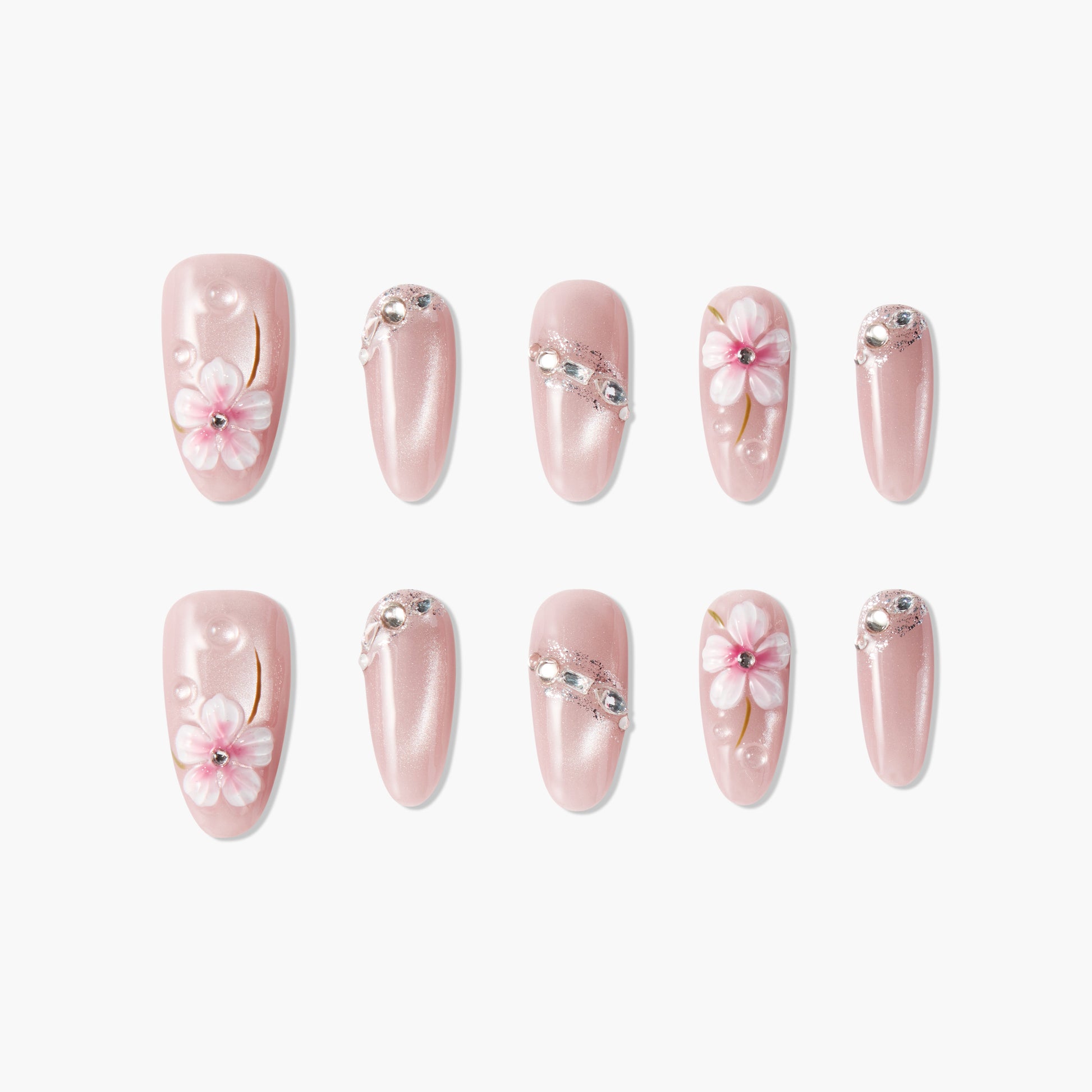 Pink press-on nails with pearl shimmer, floral designs, rhinestones, and 3D embellishments