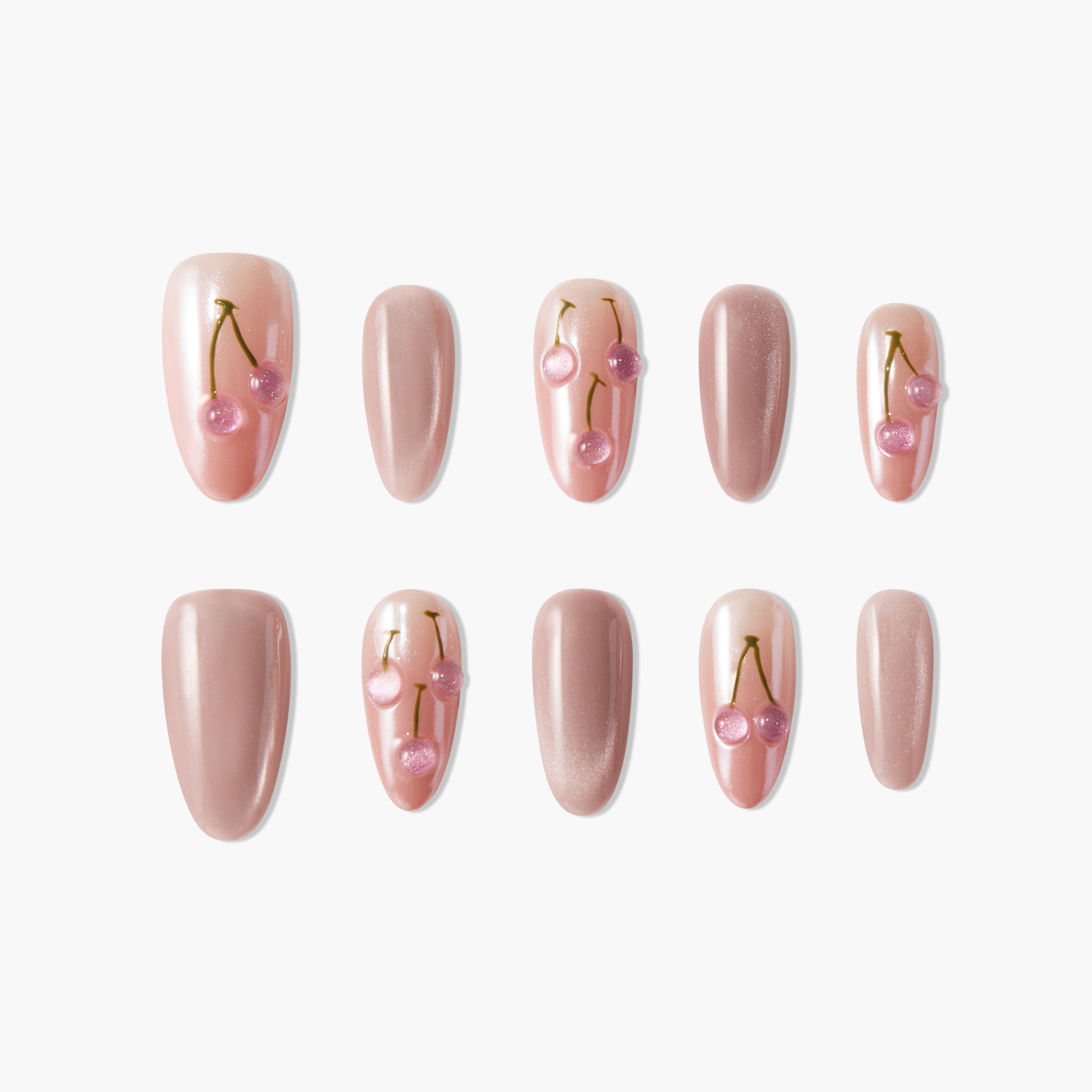 Pink press-on nails set with cherry nail art and glossy nude finish on a white background.