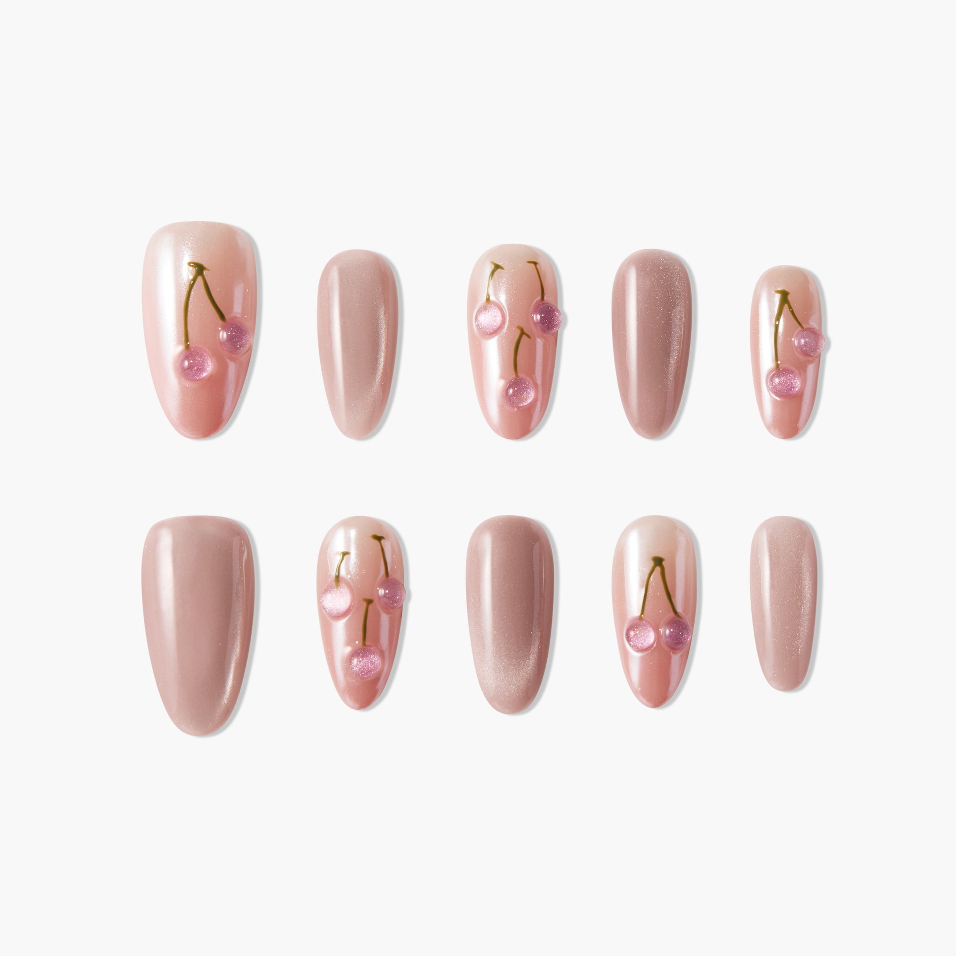 Pink press-on nails set with cherry nail art and glossy nude finish on a white background.