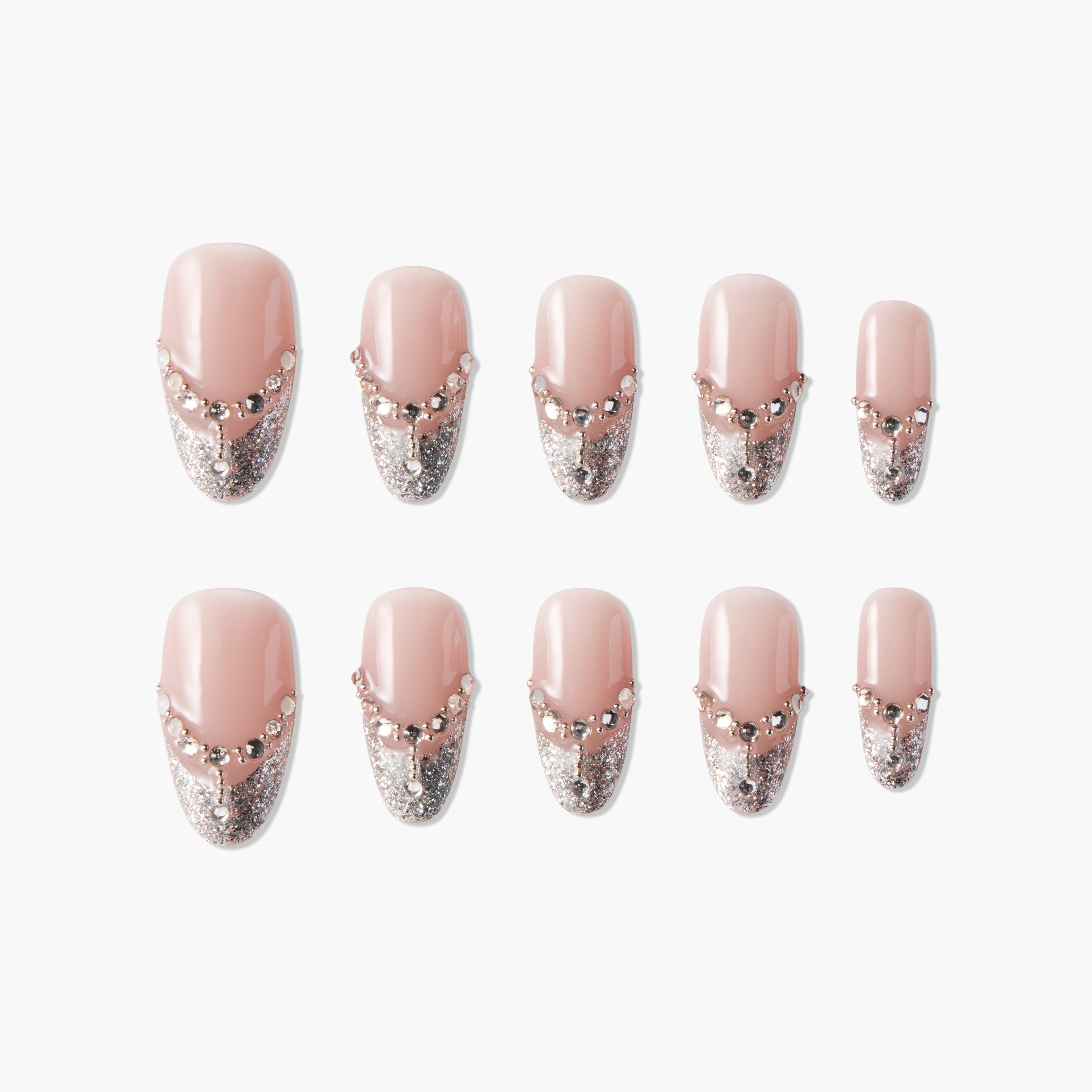 Set of pink press-on nails with silver glitter tips and rhinestone accents on white background