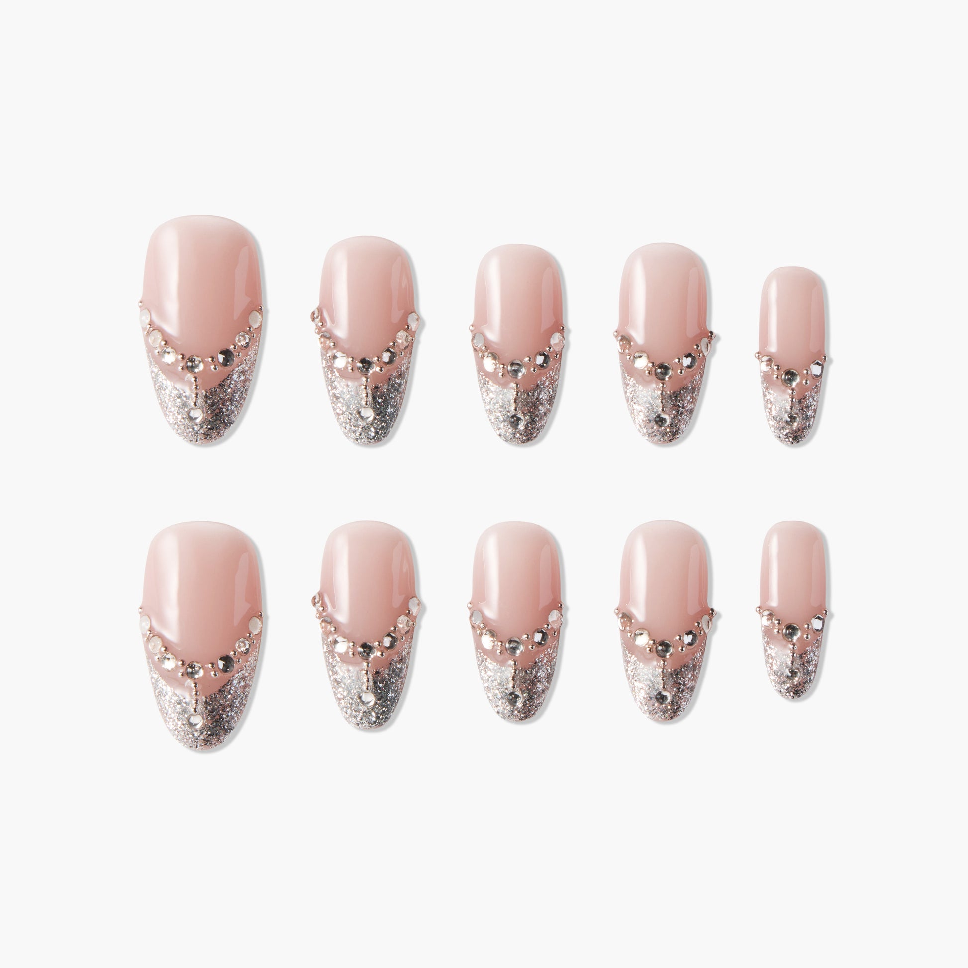 Set of pink press-on nails with silver glitter tips and rhinestone accents on white background