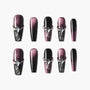 Glossy purple and black press-on nails with rhinestone and jewel embellishments