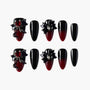 Black and red ombre press-on nails with 3D bows, gems, and heart accents on a white background.