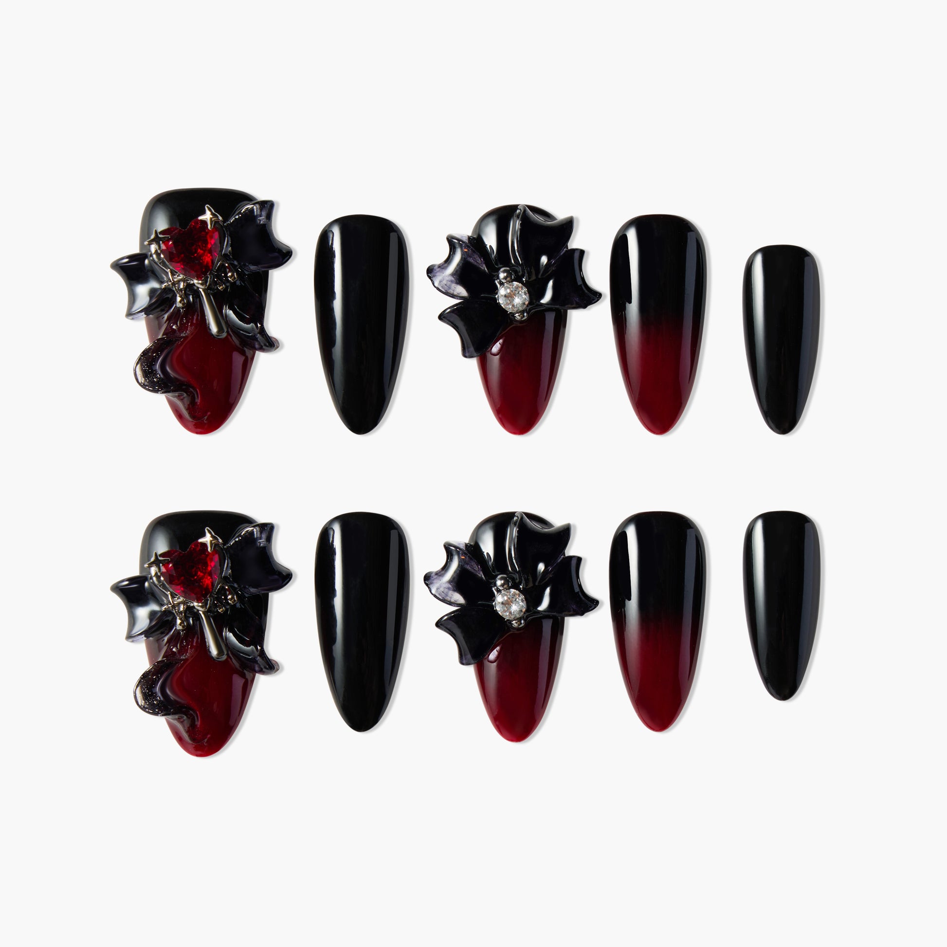 Black and red ombre press-on nails with 3D bows, gems, and heart accents on a white background.