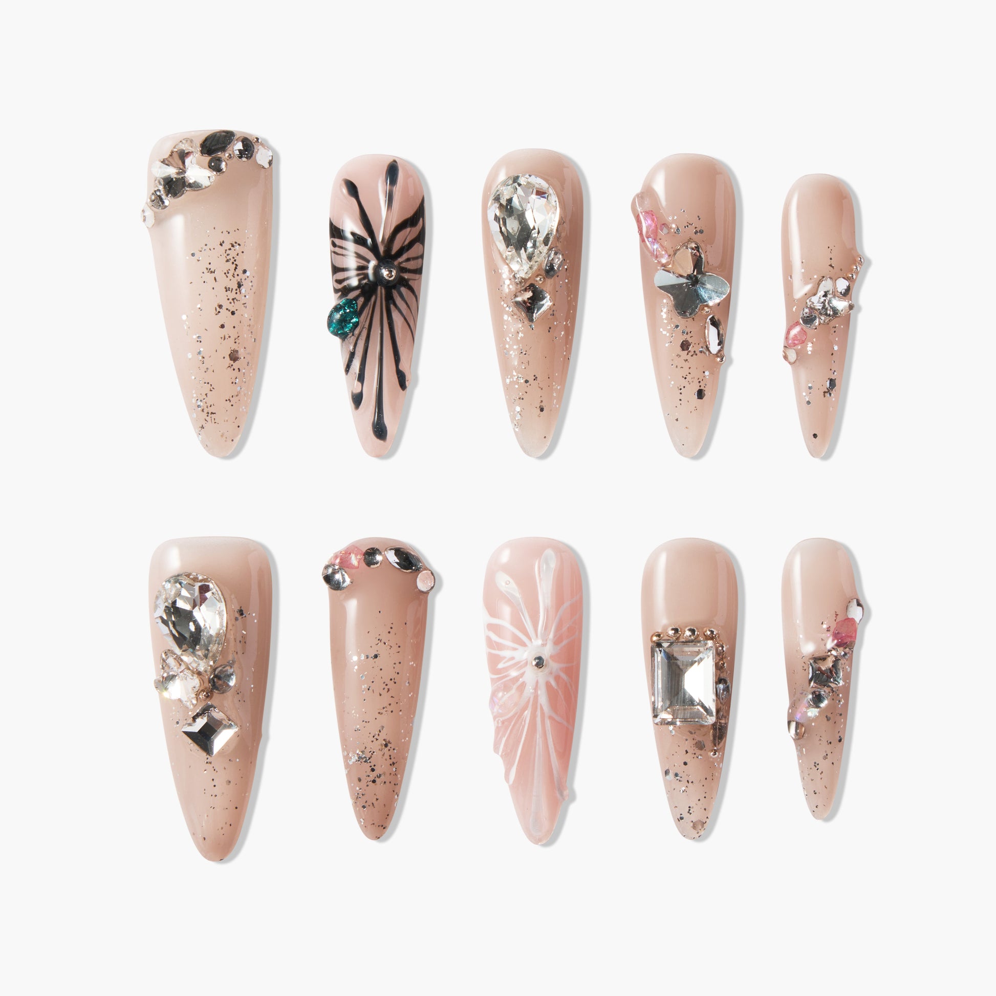 Nude press-on nails with 3D rhinestones, floral art, glitter, and gem embellishments.