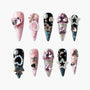Handmade press-on nails with pink, black, and glitter designs, adorned with gems and pearls