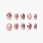 Handmade pink press-on nails with gemstone accents and glitter, elegant design set