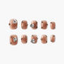 Brown press-on nails with rhinestone and gold stud accents, set on white background