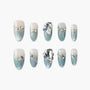Blue and white gradient press-on nails with rhinestone and heart gem accents, luxury nail design