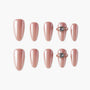 Set of glossy rose gold press-on nails with two accent nails featuring 3D gem details