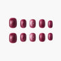 Set of glossy burgundy press-on nails with shimmer effect on a white background