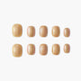 Set of glossy gold iridescent press-on nails arranged neatly on a white background