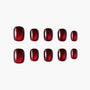 Set of glossy, deep red press-on nails with subtle shimmer on a white background