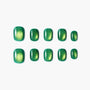 Glossy green press-on nails with metallic gold shimmer, arranged on a white background.