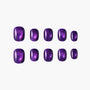 Set of glossy purple press-on nails with shimmering effect on white background