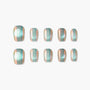Shimmery green and peach iridescent press-on nails set on white background
