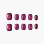 Set of glossy, deep magenta press-on nails with shimmer, displayed on white background