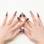 Coffin-shaped handmade press-on nails in metallic purple and black with crystal accents.