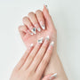 Long stiletto press-on nails with white tips and large silver rhinestone accents