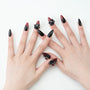 Handmade press-on nails with glossy black and red design and 3D floral accents