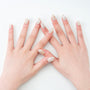 Hands with elegant nude press-on nails adorned with gold and silver metallic accents