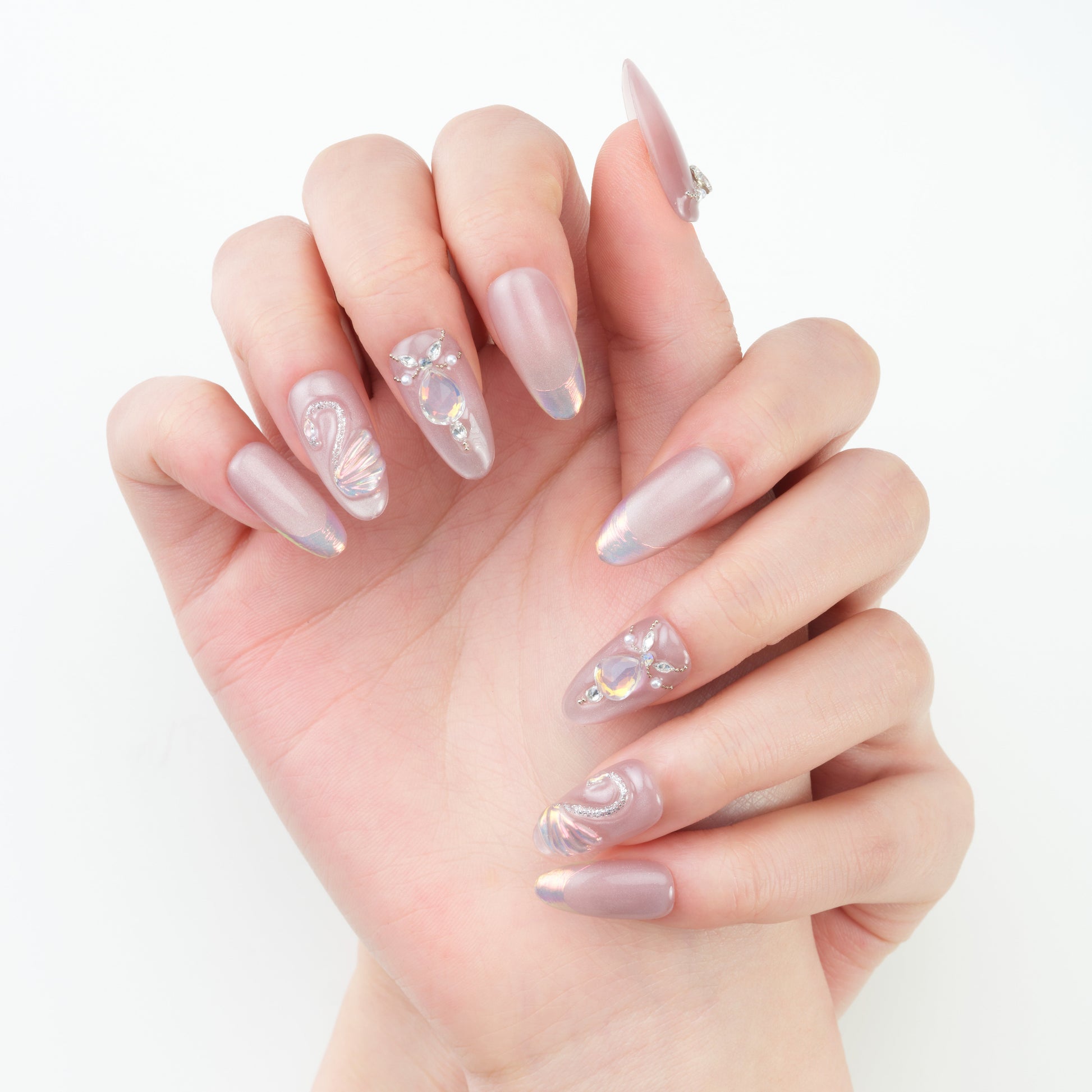 Hand with long, iridescent pink press-on nails and 3D rhinestone nail art