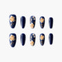 Navy blue press-on nails with gold 3D floral and leaf designs, arranged on white background.