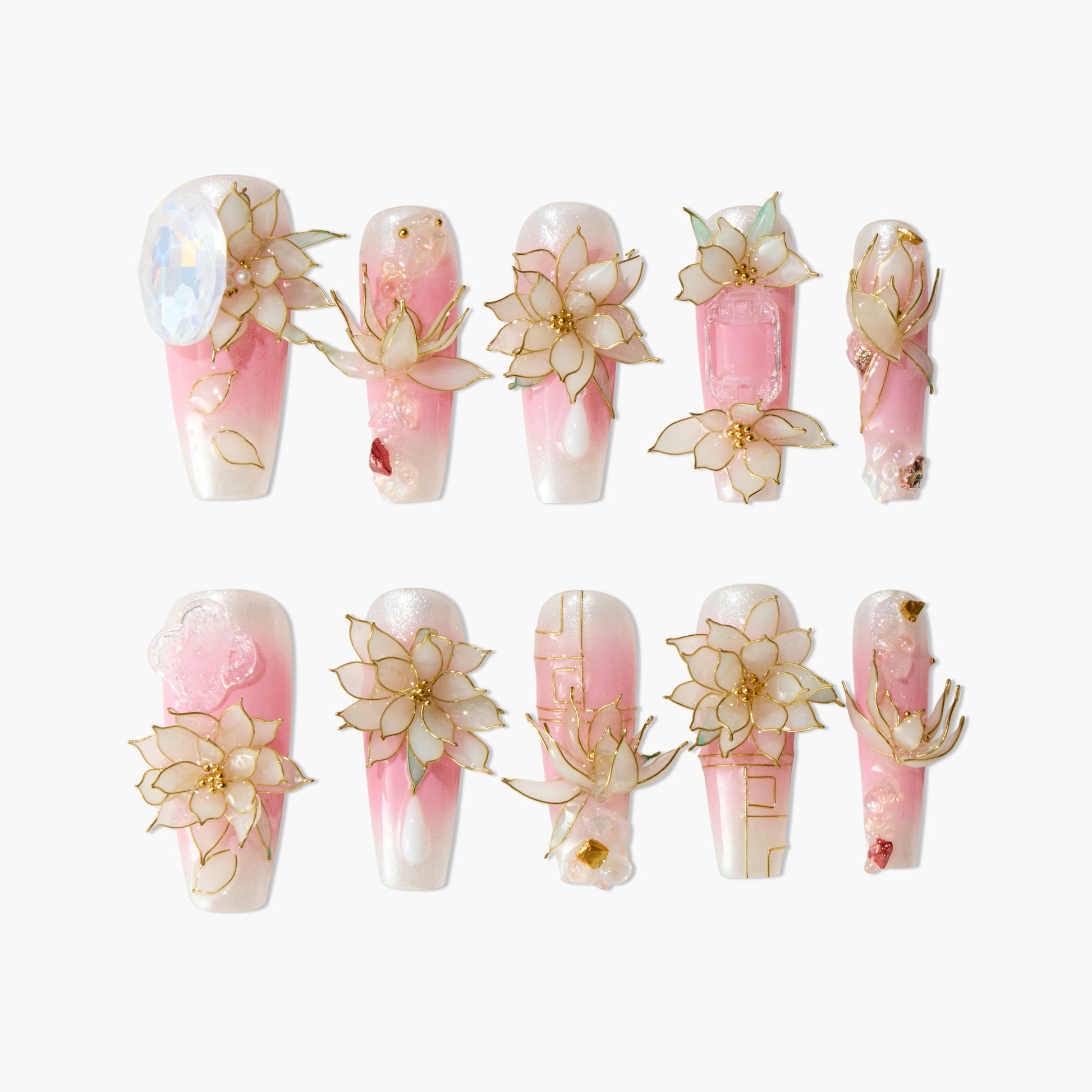 Handmade press-on nails with pink and white ombre, 3D floral designs, and gold accents