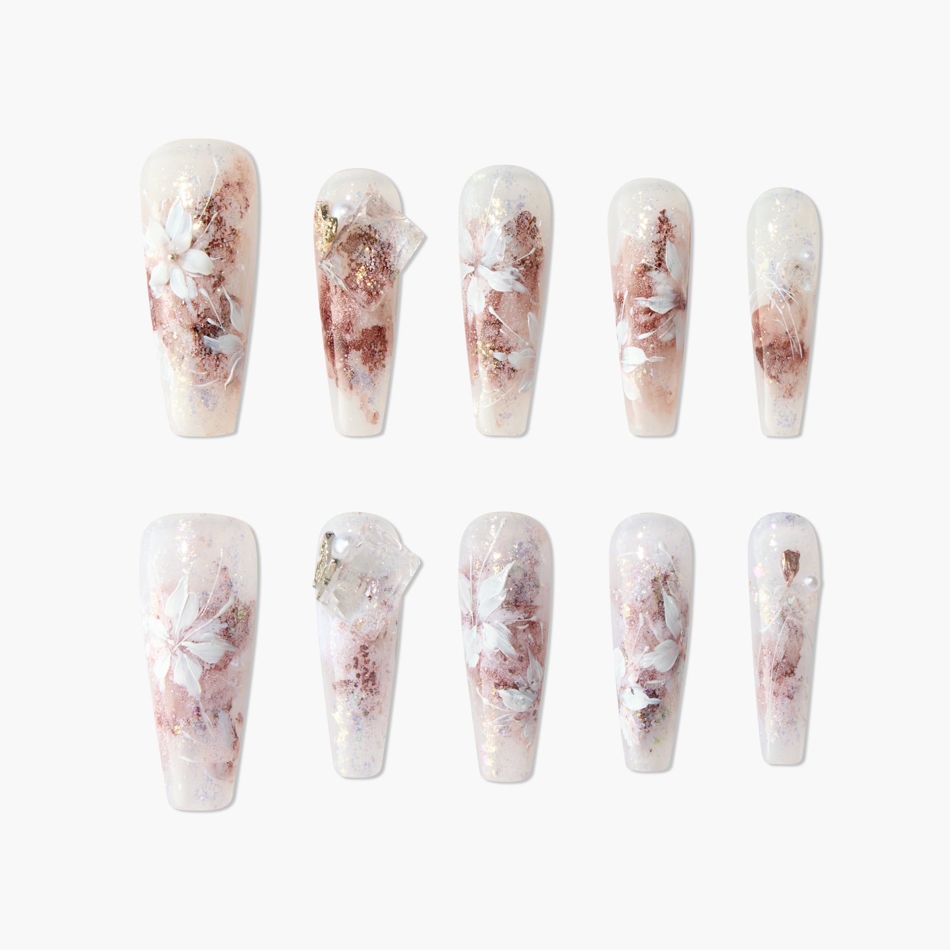 Handmade press-on nails with white floral designs, rose gold foil, and shimmery accents