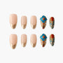 Handmade press-on nails with nude and gold tips, blue floral accents, and gemstone detailing