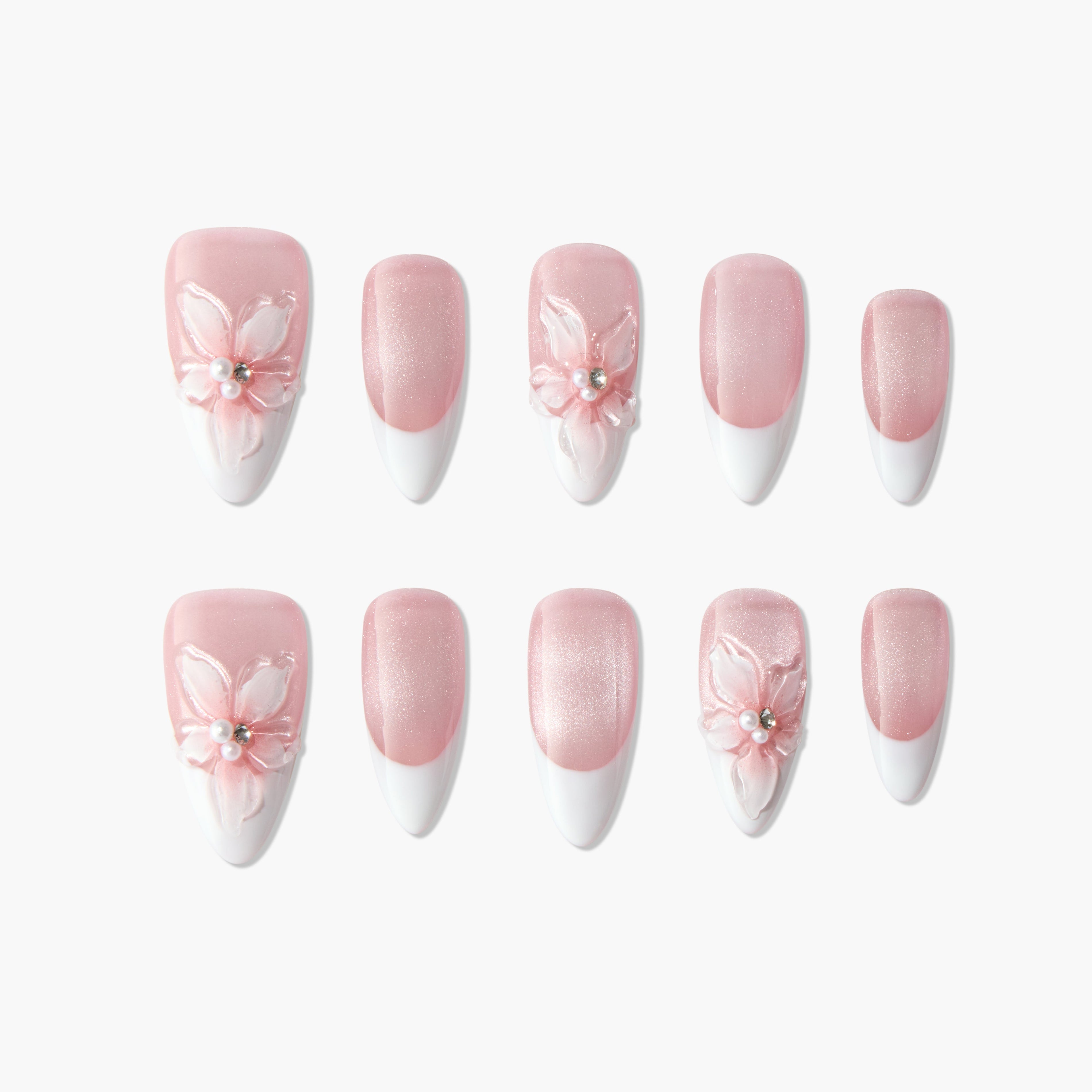 Pink and white French tip press-on nails with 3D floral and pearl accents, arranged on white background