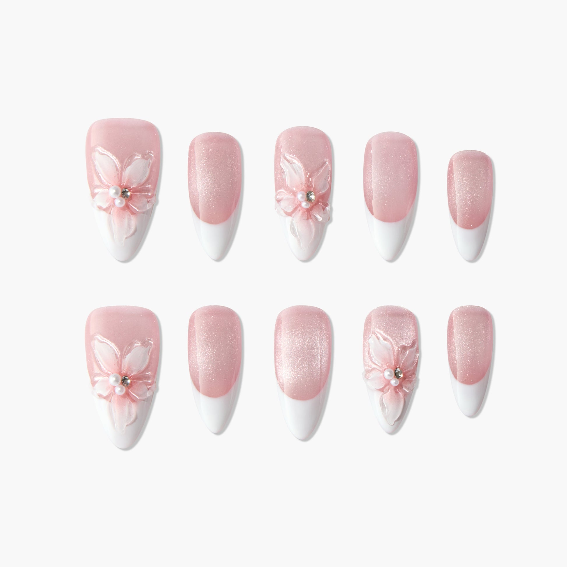 Pink and white French tip press-on nails with 3D floral and pearl accents, arranged on white background