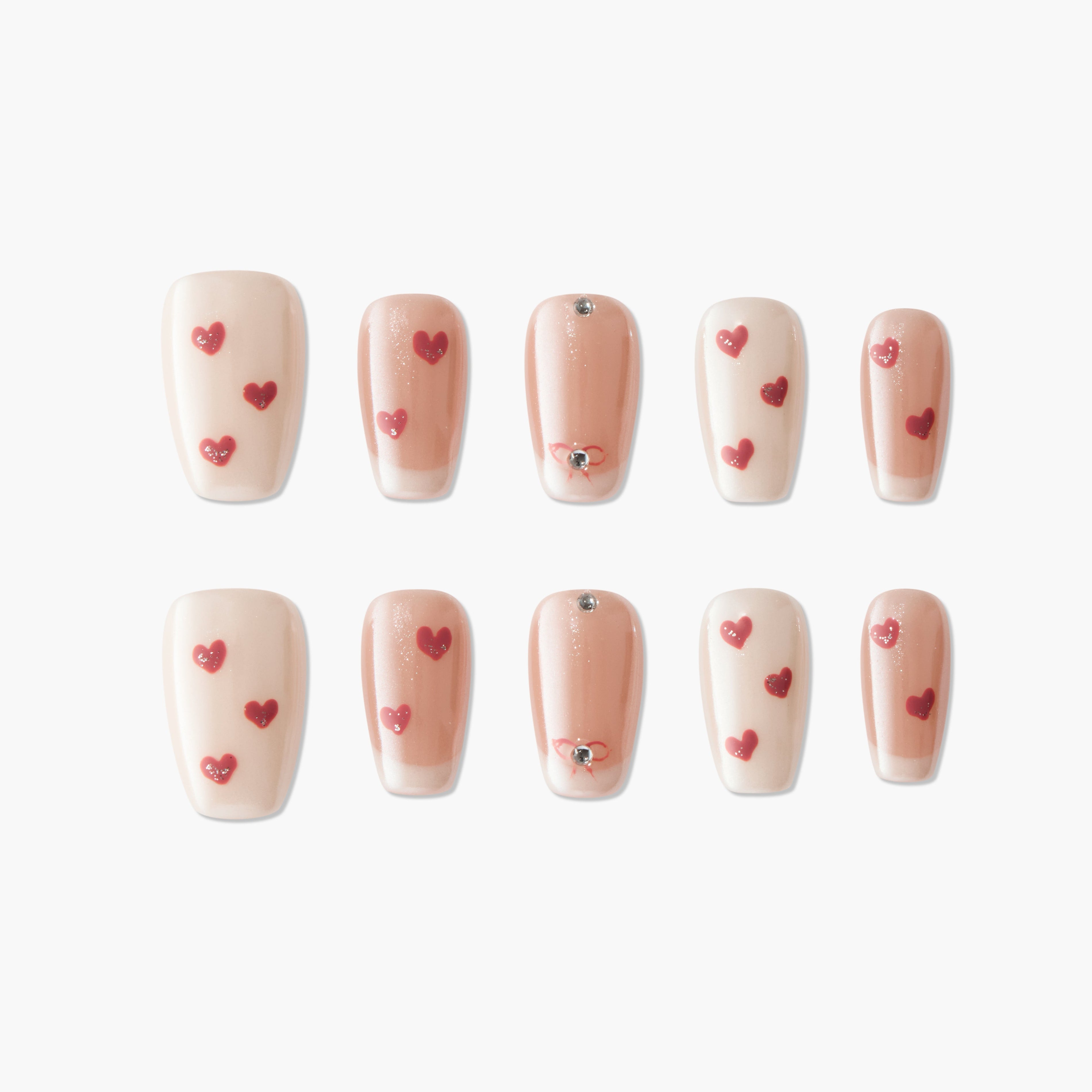 Handmade press-on nails with nude and blush tones, red heart designs, and rhinestone accents