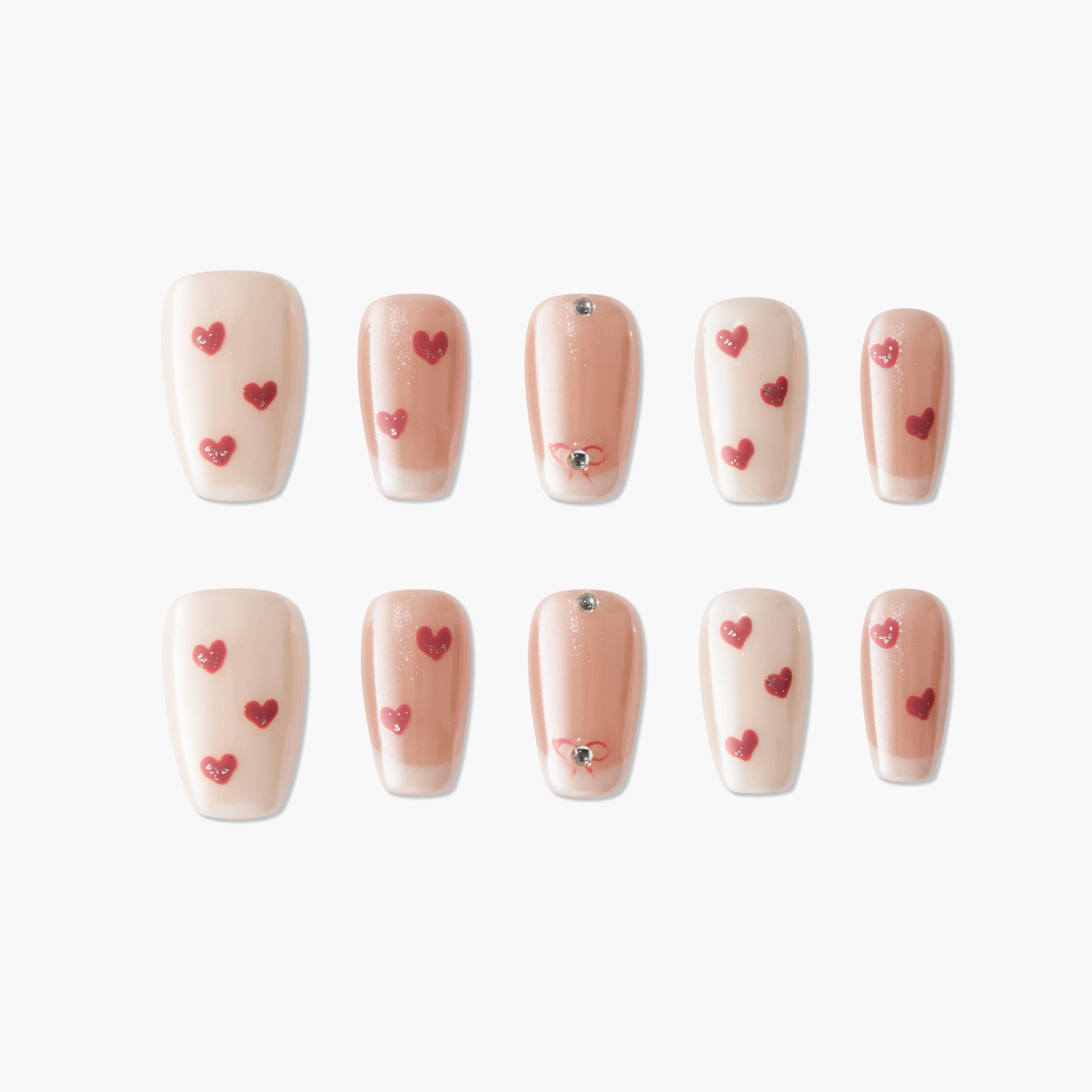 Handmade press-on nails with nude and blush tones, red heart designs, and rhinestone accents